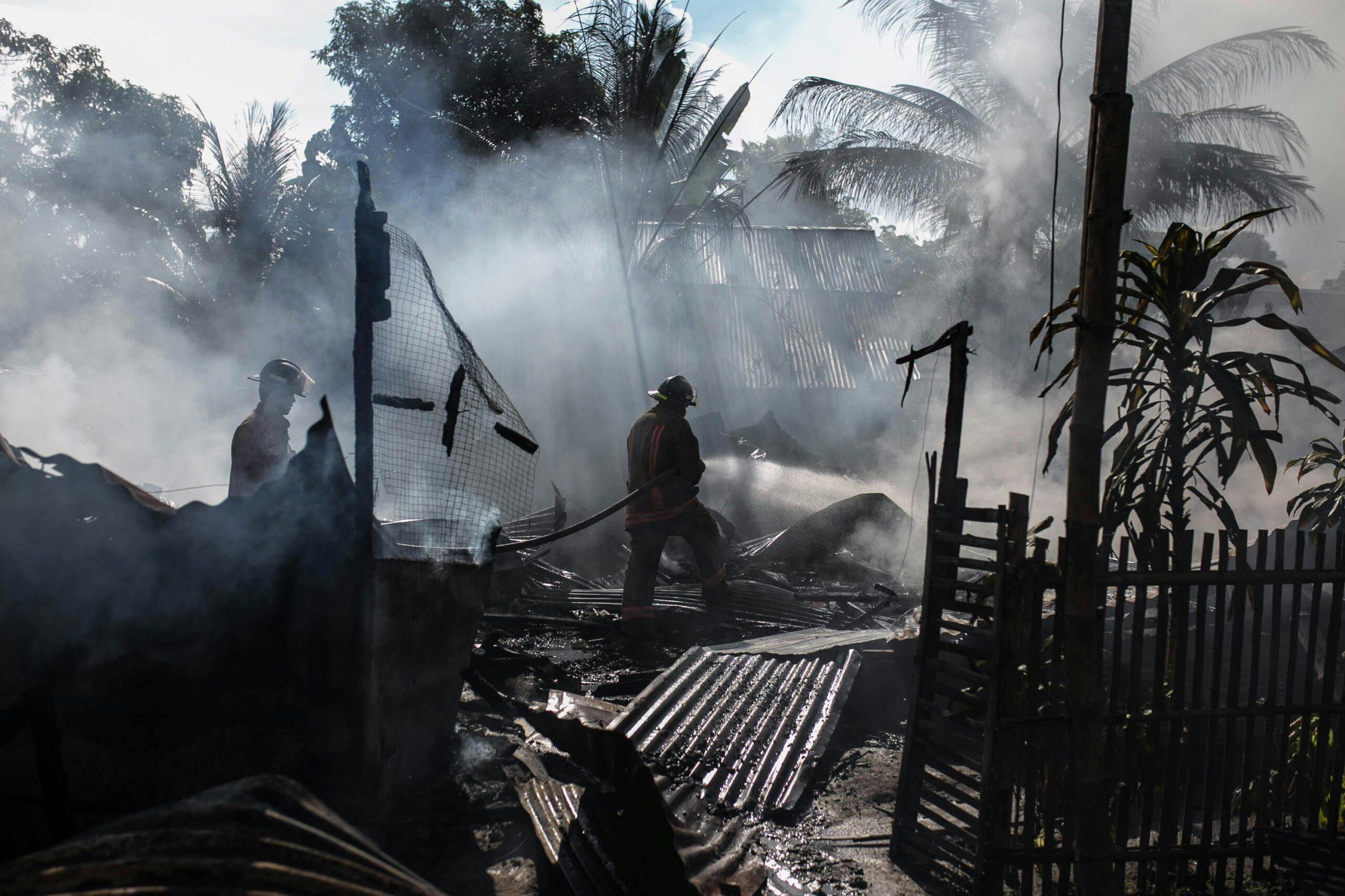 firefighters amid fire wreckage