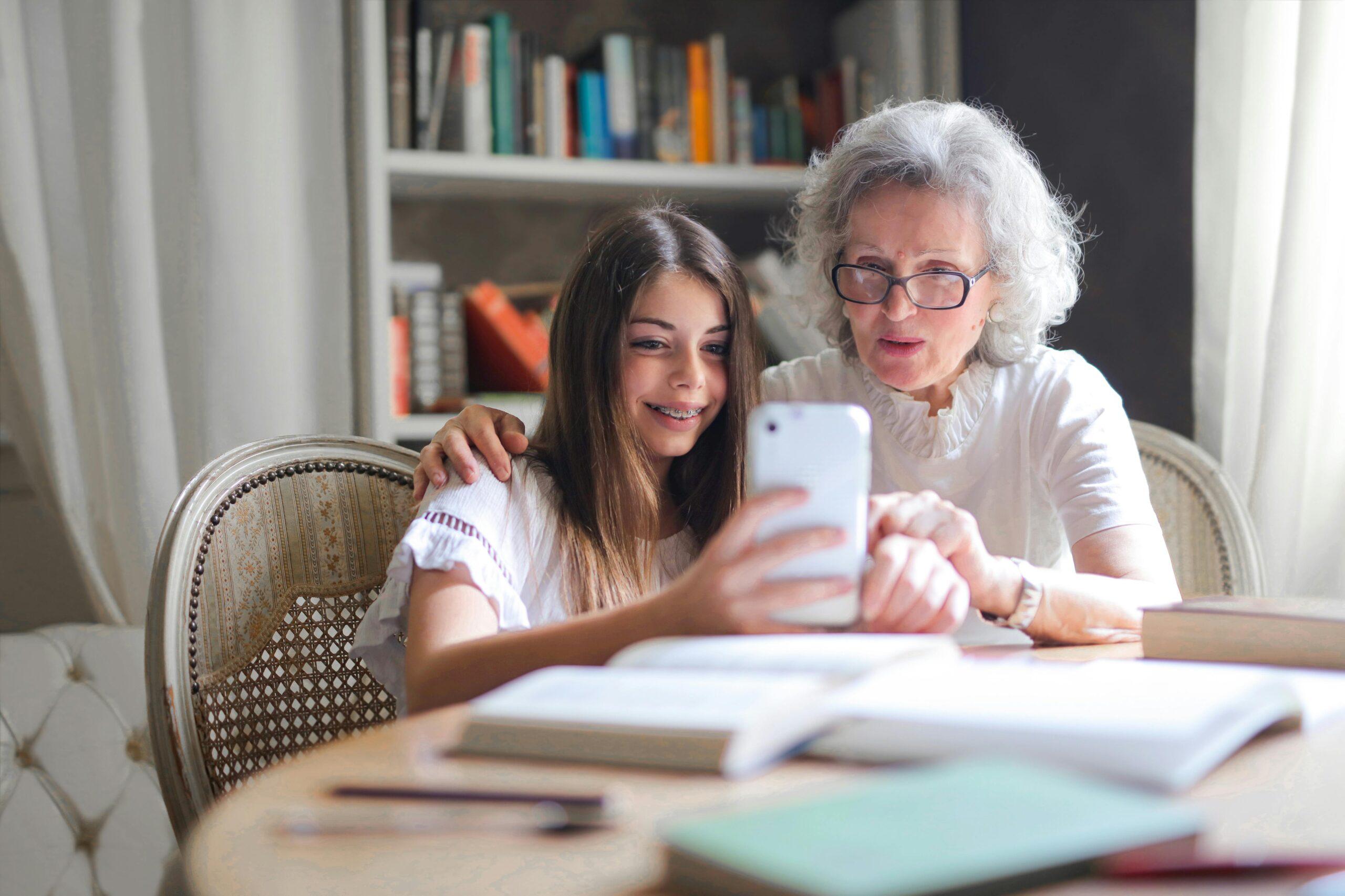 grandma looking at phone with granddaughter